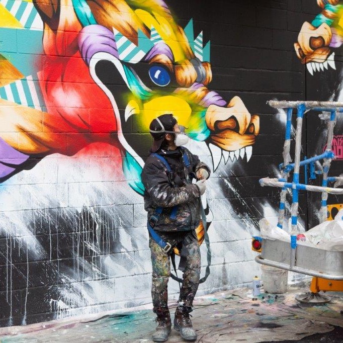 taka sudo in front of his mural artwork gallery